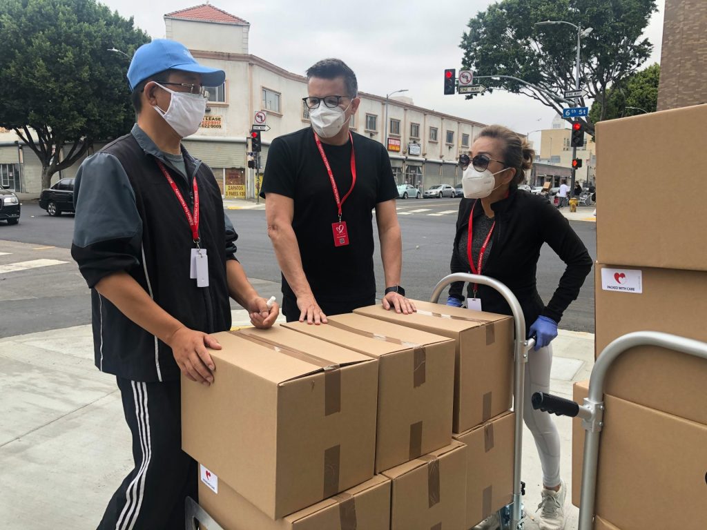 Tres personas de pie al lado de cajas